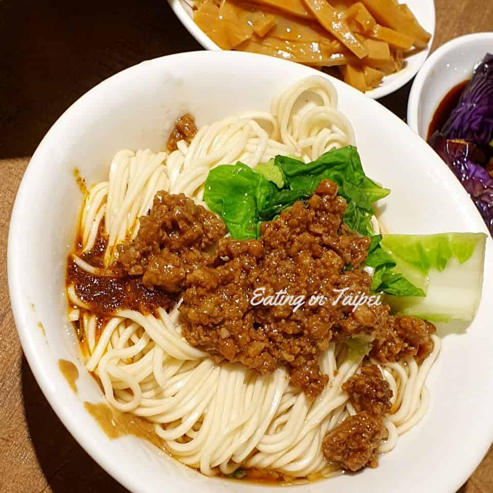 This is a noodle dish with meat sauce and veggies.