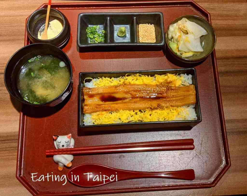 The eel lunch set at Nihombashi Tamai comes with rice and egg underneath the large eel portion, a bowl of miso soup, pickles, and a dessert.