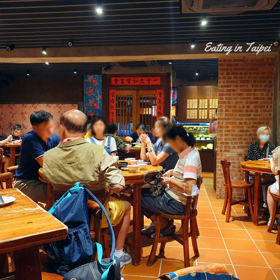 Inside, there are old-school wooden chairs and round tables, mostly packed with people. There are classic tiles on the floor, and lots of exposed brick.