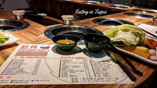 your classic view at any hot pot restaurant - paper place mat with the menu printed on it, and a lot of cutlery and plates.